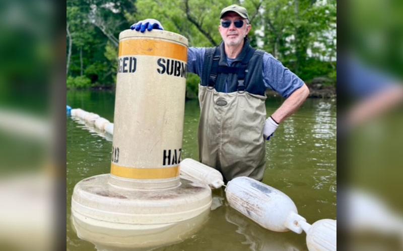 Don Mull stands next to a hazard float during the clean up of Lake Blue Ridge where 14.6 tons of debris were collected.