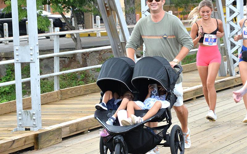 The event is not just for runners, but invites everyone to enjoy the event as this father shows as he pushes two youngsters across the iconic steel bridge.