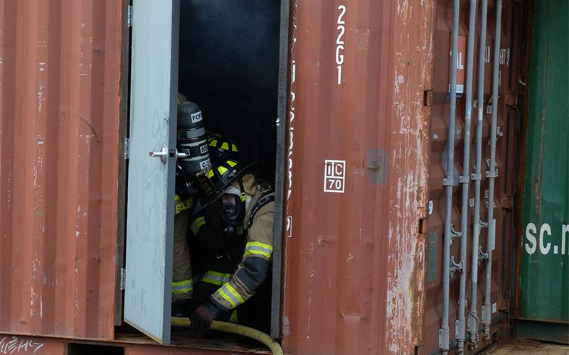 Training hours play a big part in an ISO rating. Here, two Fannin County firefighters work to maneuver a hose into the department’s burn building as part of a real life scenario. Smoke can be seen rising from inside the building.