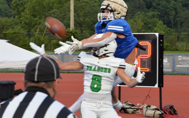 Braden Taylor goes over the top of a Pickens Dragon defender to fight for a pass Friday night. The Rebels host White County in a scrimmage this Friday.
