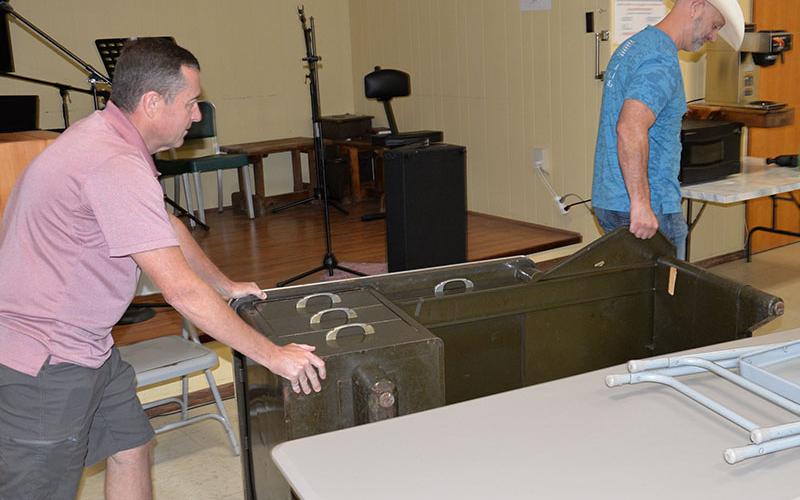 Keith Barker, left, Polk County District 3 commissioner, and Polk County District 2 Commissioner Shane Bowman remove a heavy metal desk from the Copper Basin Community Center. The desk was a piece of surplus property that was cluttering the building.