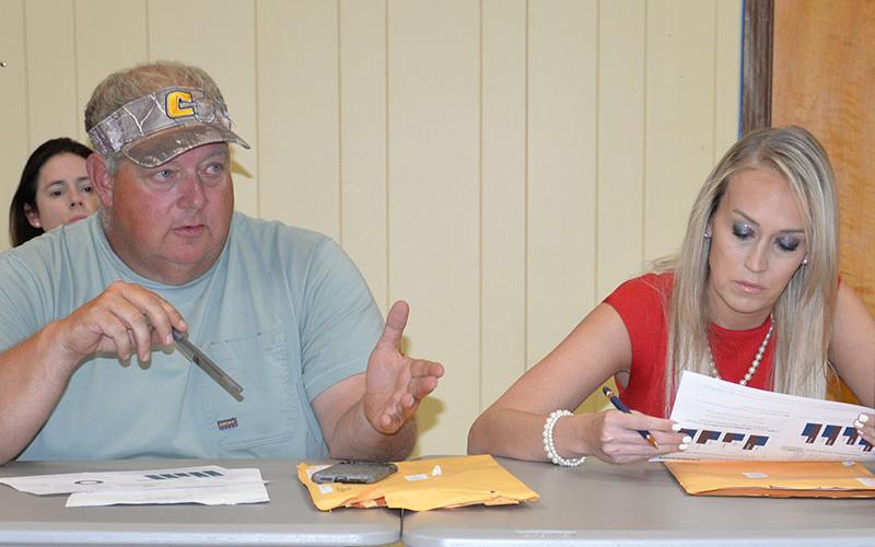Polk County Commissioner Greg Brooks makes a point about total tourism dollars versus tax dollars as Commissioner Samantha Trantham studies a Department of Tourism handout.