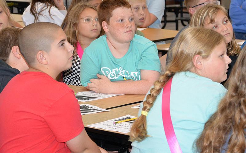 Talton Evans, center, listens as Blue Ridge Elementary School fifth graders learn the importance of respecting the U.S. flag.