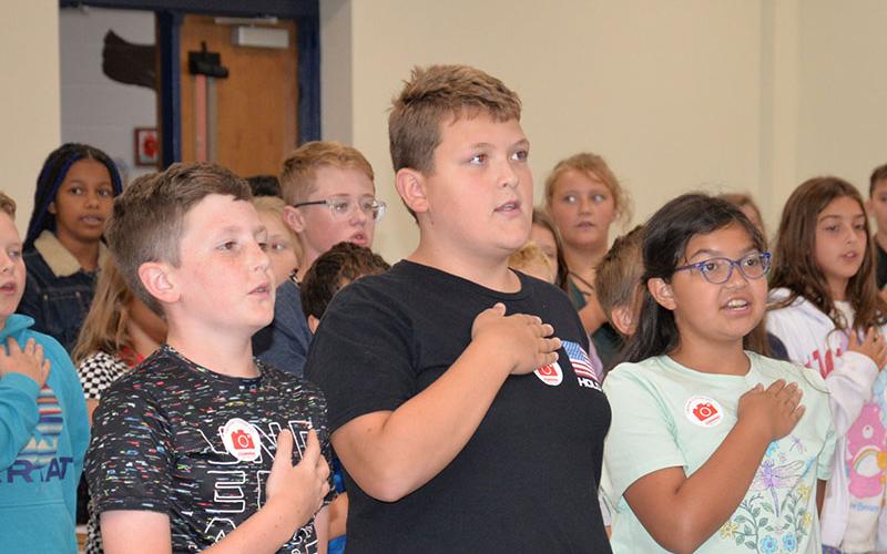 Cason Pierce, Izaiah Bradburn and Isabella Castro, from left, say the Pledge of Allegiance as a flag etiquette class got underway at Blue Ridge Elementary School. Fifth graders were taught respect for the U.S. flag and its deep rooted history by members of the North Georgia Honor Guard.