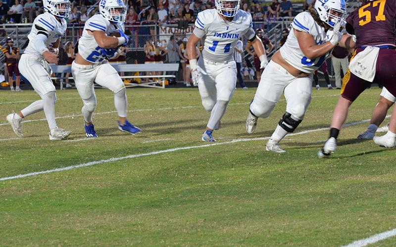Jacob Dye (#60) and Cooper Born (#14) clear a patch for Carson Callihan (#25) after he takes a handoff from Lawson Sullivan (#2) in the Fannin County Rebels road game against the Dade County Wolverines in Trenton, Georgia, Friday night. The Rebels won the contest to go 5-0 on the season.