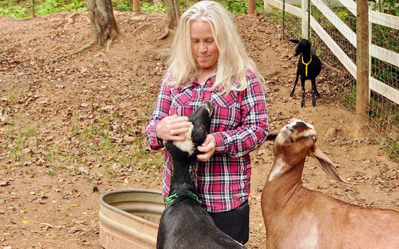 News Observer photo/Mollie Morrow Beth Raque has always been fond of animals as seen here with these goats.