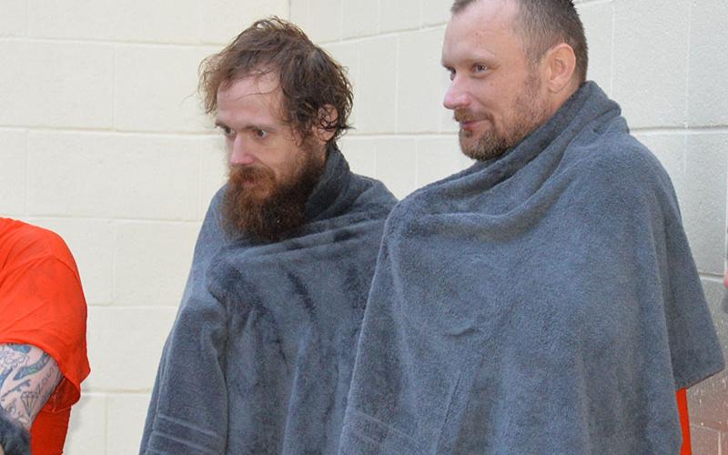 Brandon O’Neal, left, and Randall Jones wrap up in towels to dry off and get warm after being baptized at the Fannin County Jail. The water in the tub used for the ceremony came straight from a hose, just as cold as if the men had been baptized in a Fannin County creek.