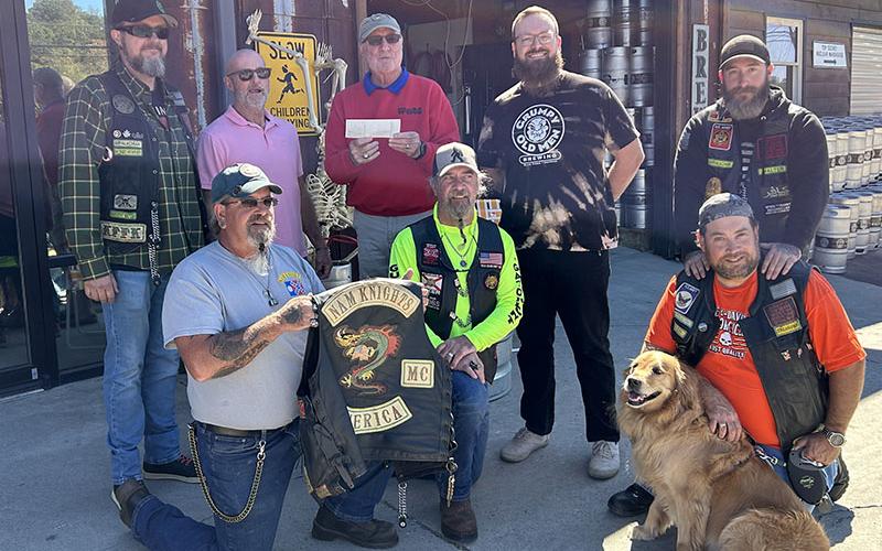 Dale Greene, co-coordinator of Toys for Tots of Fannin County, along with Jeff Young, owner of Grumpy Old Men Brewing, accepted a $1,900 from Nam Knights Motorcycle Club members. The club raised the money on a ride through Fannin County. Grumpy Old Men is a regular supporter of Toys for tots, and will host its annual fundraiser November 29.