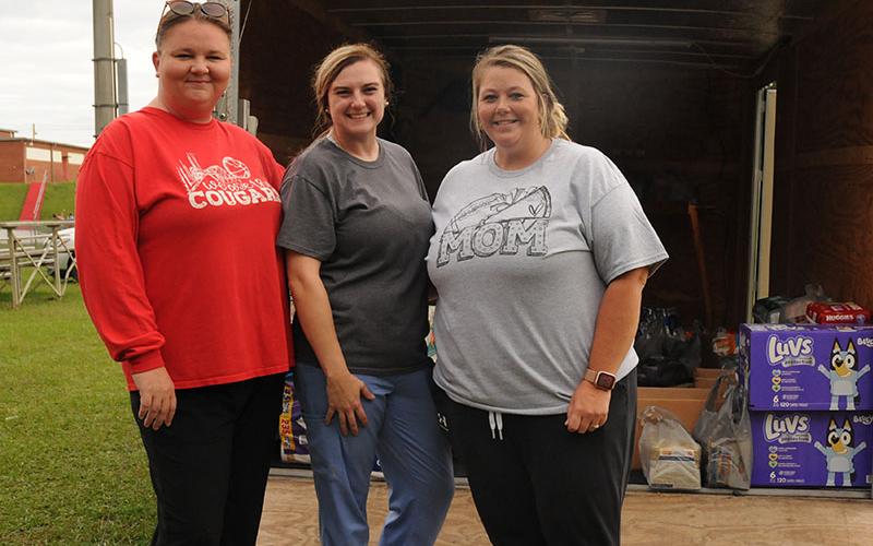 Monica Hicks, Heather Cochran and Megan Mosley, from left, take a moment from loading donations for Copper Basin Recreation Association’s relief efforts for Western Carolina Tuesday, October 1. They ended up filling two trailers and trucks full of donations, which they took early Friday morning. The league competes against several teams that were affected by Hurricane Helene’s tropical storms.