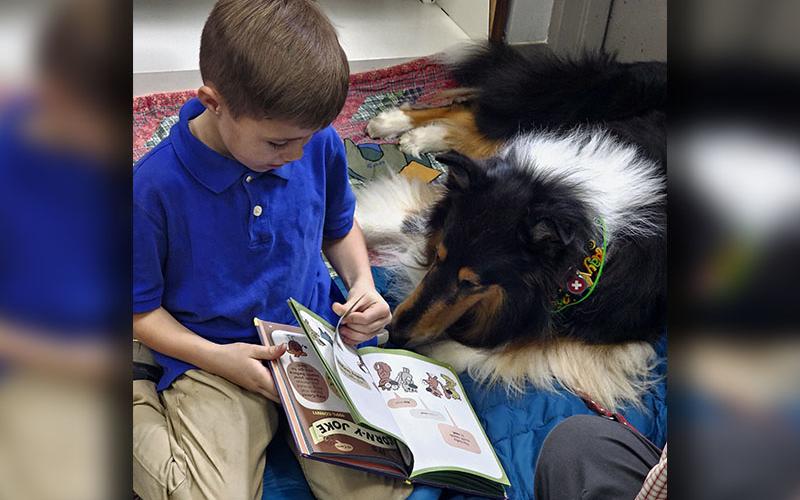Everett Young is shown with Calder at the Book Buddies with Calder Reading Dog Program at the Fannin County Public Library.