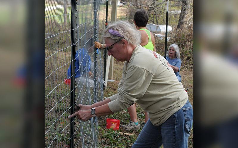 Sandra Simpson secures the fence to a post for Freedom for Fido’s 150th fence build to date.