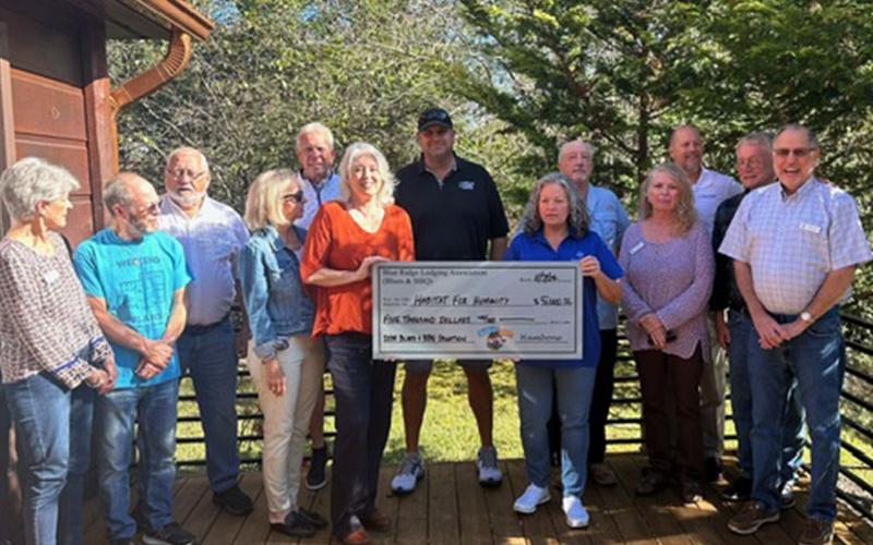 Representatives of Habitat for Humanity accepted a $5,000 check from Blues &amp; BBQ representatives Paul Gribble and Greg Spencer.