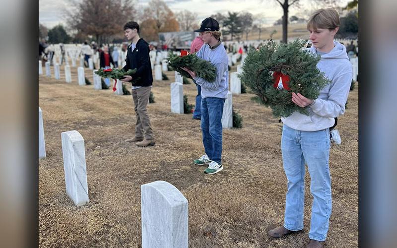 Copper Basin High School seniors Seth Picklesimer, Malachi Kemper and Patrick Legate, from left, are shown during their service project where they participated in Wreaths Across America in Chattanooga, Tennessee.