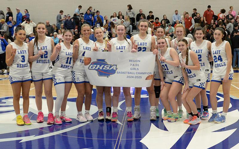 Members of the Fannin County Lady Rebels basketball team proudly display the banner recognizing them as 2024-2025 Region Champions. The Lady Rebels won the title Friday night at Gordon Central High School in Calhoun.
