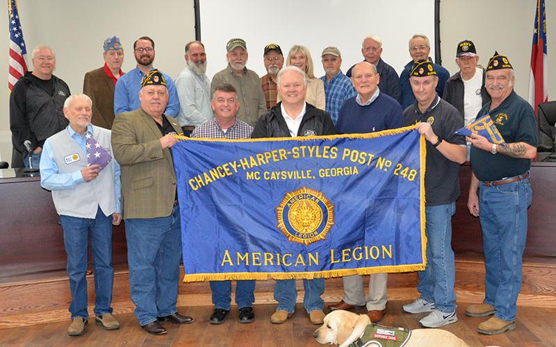 A trio of flags are destined to be framed and hung in the commission conference room in the Fannin County Courthouse. Shown during the presentation are, from left, front row: Walt Polk, James Callender, Jaime Hensley, Johnny Scearce, Glenn Paterson, John Tucker and Bruce Fowler; and, back, John Chastain, Danny Drake, Michael Earley, Tim Doherty, Jerry Chastain, Bud Chastain, Susan Kiker, Terry Arp, Larry Collis, Billy Wayne Chastain, and Bruce Weber.