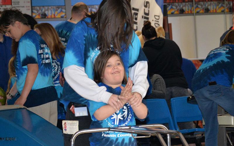 Sunshine Gibbs and Bree Twiggs celebrate a successful roll at Special Olympics bowling.