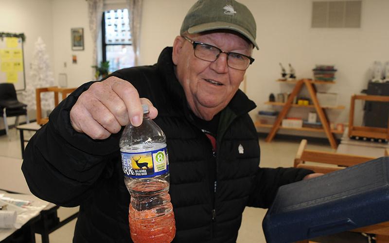 Carl Riggs, the Georgia council chairman for Trout Unlimited, displays a water bottle filled with rainbow trout eggs that he delivered to Blue Ridge Elementary School last week.
