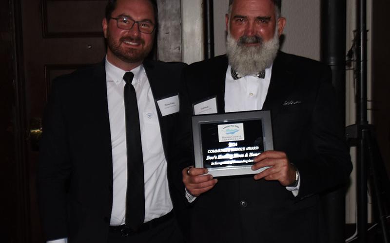 Tim Doherty accepted the community Service Award from Michael Earley, left.