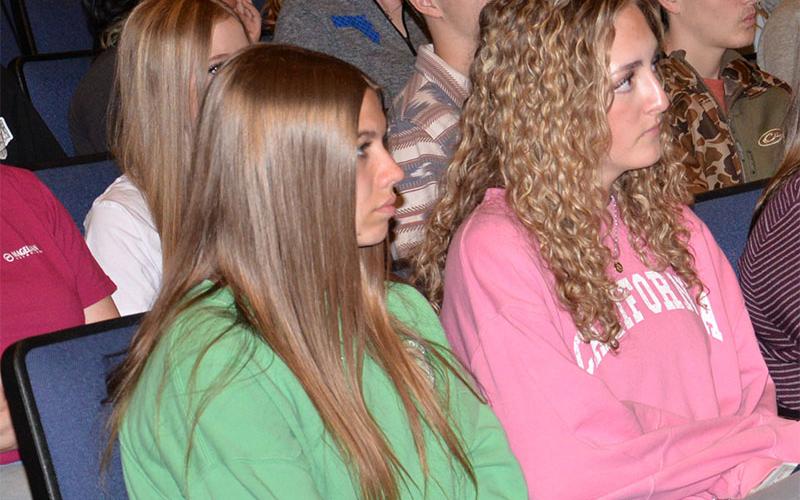 Emma Weaver, left, and Avery Collis listen as law enforcement officers explain their roles regarding enforcement of traffic laws.