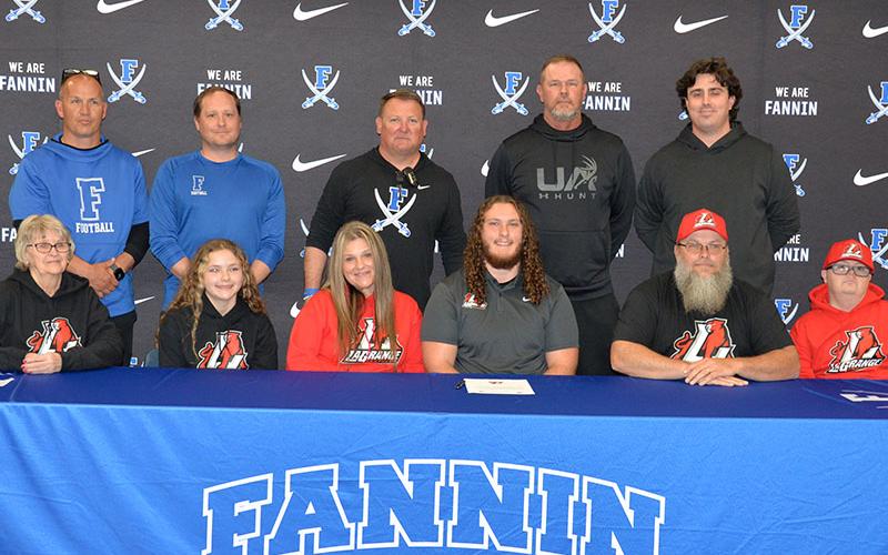 Rebel football player Jacob Dye, seated, center, committed to further his football career with LaGrange College Monday, April 7. Dye is shown surrounded by family and coaches, seated, from left, Karen Henry, Emmalyn Dye, Shannon Dye, Kevin Dye and Chad Henry; back, Ryan Holloway, Wade Woodall, Head Coach Chad Cheatham, Jeff Kuna and Jacob Reece.