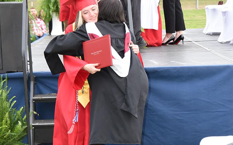 Trinity Smith gets a big hug from Zulma Youngs after receiving her diploma.