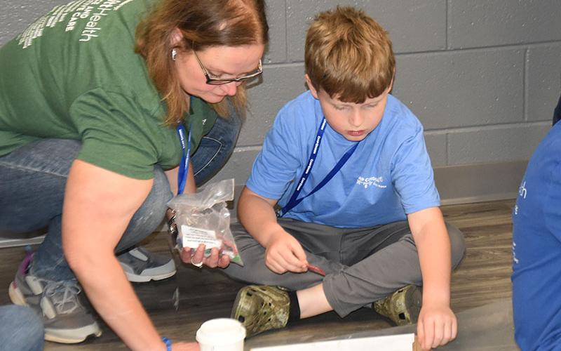 Gunner Westphal gets help with his project from Mary Beth Westphal during Camp Cocoon.
