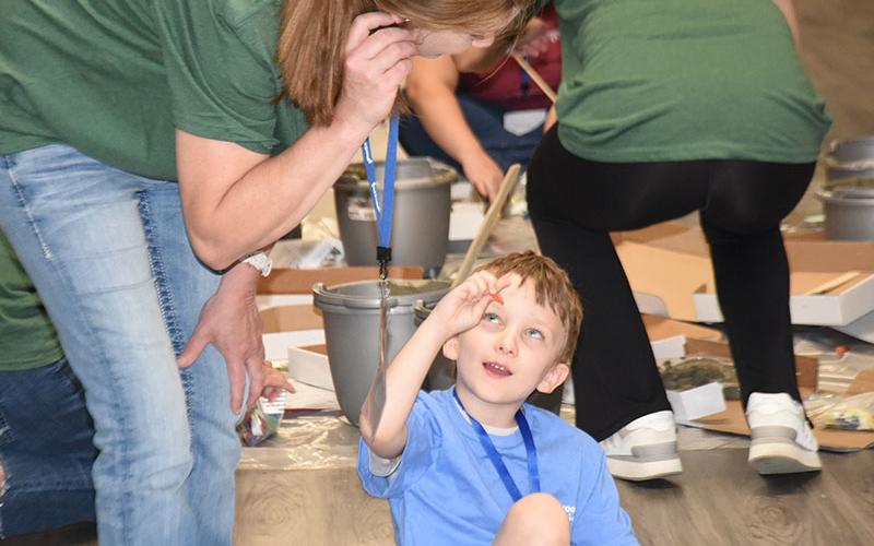 Zane Sanderlin shows off the next decoration he will be using to Julie Week during Camp Cocoon sponsored by PruittHealth Hospice. The event was designed to help children cope with the loss of a loved one.