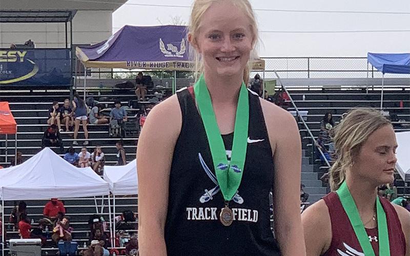 Adia Galloway stands with her medal recognizing her sixth place finish in State Championship Pole Vault competition.