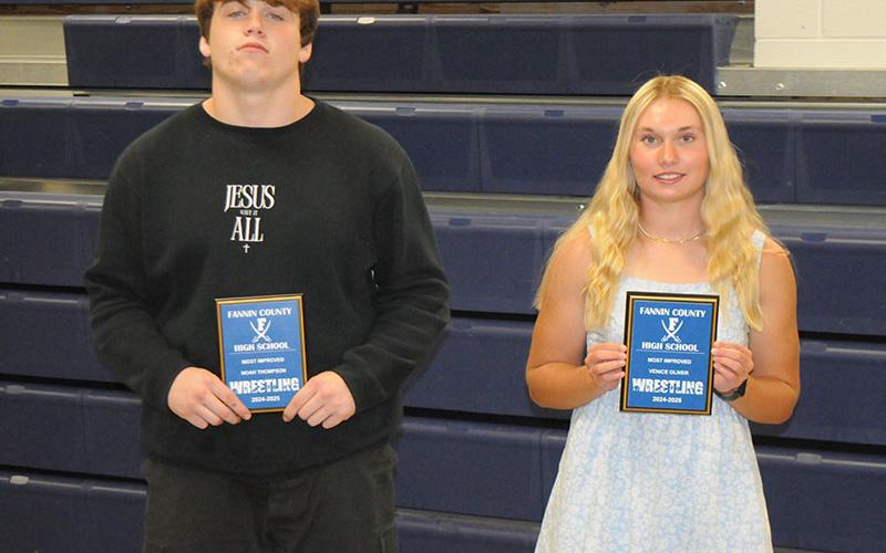 Wrestling team members Noah Thompson, left, and Venice Oliver, right, receive the Most Improved awards April 28.