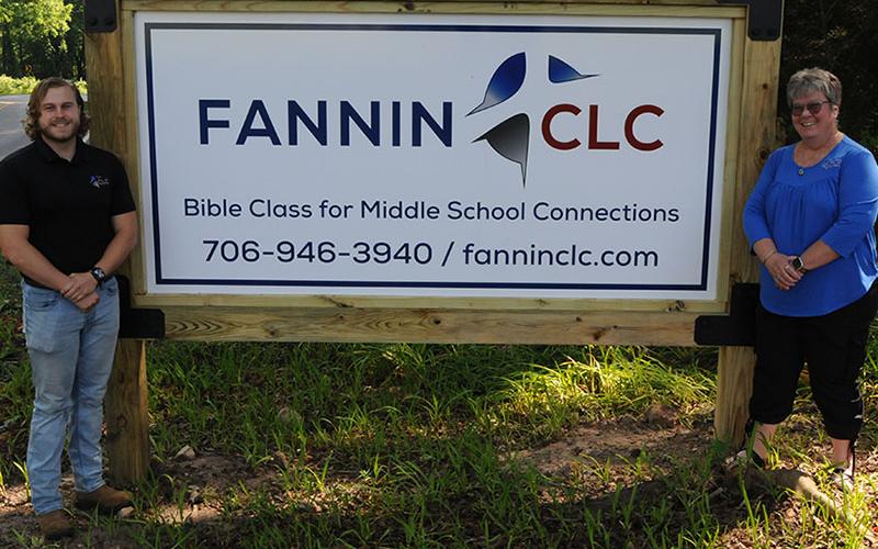 Jared Herum and Tina Lee display the sign for the new Fannin Christian Learning Center.