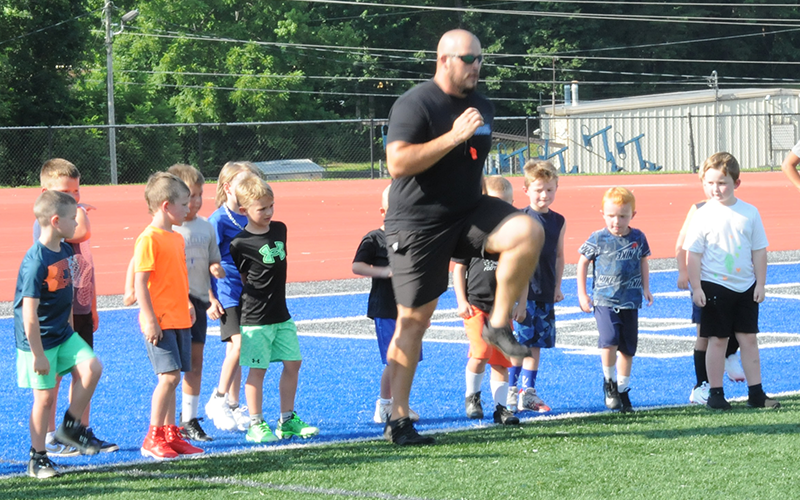 Fannin County High School Coach Logan Daves leads new players in their drills during youth football camp.