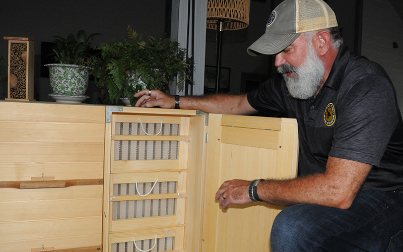 Tim Doherty demonstrates a beehive box that can be easy to use for veterans with disabilities.