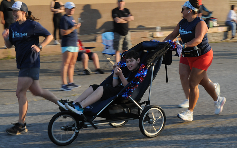 Aiden Mullins races in the Blue Ridge Freedom 5K. Mullins was one of five racers taking part in the Friday morning event thanks to the volunteers working with the Kyle Pease Foundation. The foundation works to provide opportunities for athletes with disabilities. Ashley Weeks is Fannin County’s Community Engagement Coordinator for the organization.