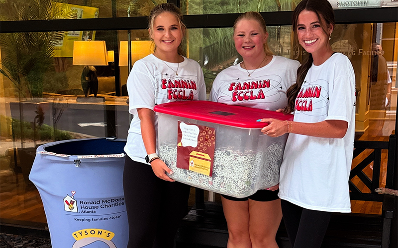 Eleanor Hodgson, Lyla Webb, and Adeline Beavers, from left, carry the tote filled with thousands of pop tops donated to the Ronald McDonald House of Atlanta. Collecting the tops was part of a FCCLA project at Fannin County High School.