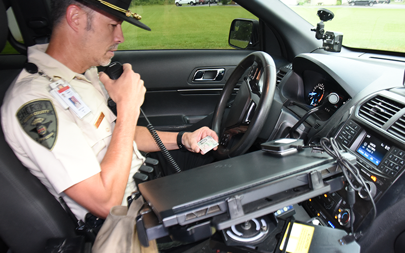 Fannin County Deputy Sheriff Captain Darvin Couch checks the drivers license of a driver stopped for speeding in the Blue Ridge Elementary School Zone on Highway 515. Until now, Couch said deputies had been working to educate drivers as to the speed limits. Now, deputies will be issuing citations.
