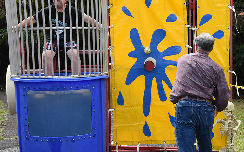 U.S. Representative Andrew Clyde takes a shot at Fannin County Commission Chairman Jamie Hensley who had volunteered to sit in the dunking booth Saturday.