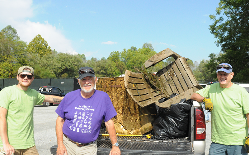 Carter Ott, Harmon Smith and Steve Williamson, from left, found a chair and what seems to be an old refrigerator in the river during Rivers Alive at Tammen Park September 27.