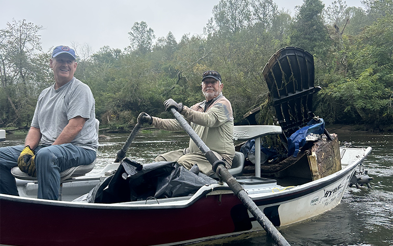 Steve Williamson, left, and Harmon Smith gather garbage by the boat load during the Rivers Alive cleanup on the Toccoa River September 27.
