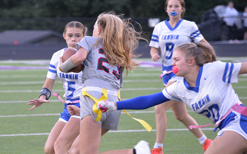 Fannin high flag football junior AnnaLeigh Cheatham (#20) pulls the flag of a Dalton Academy player as sophomore Kendall Gaddis (#5) runs for the tackle and Lynnex Patterson (#9) runs to assist. Fannin won the game 35-6 in Gilmer County Oct. 9.