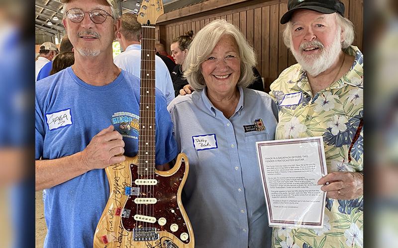Greg Spencer, Debby Beck and Carl Pruett, from left, are shown with the autographed Fender six-string Stratocaster.