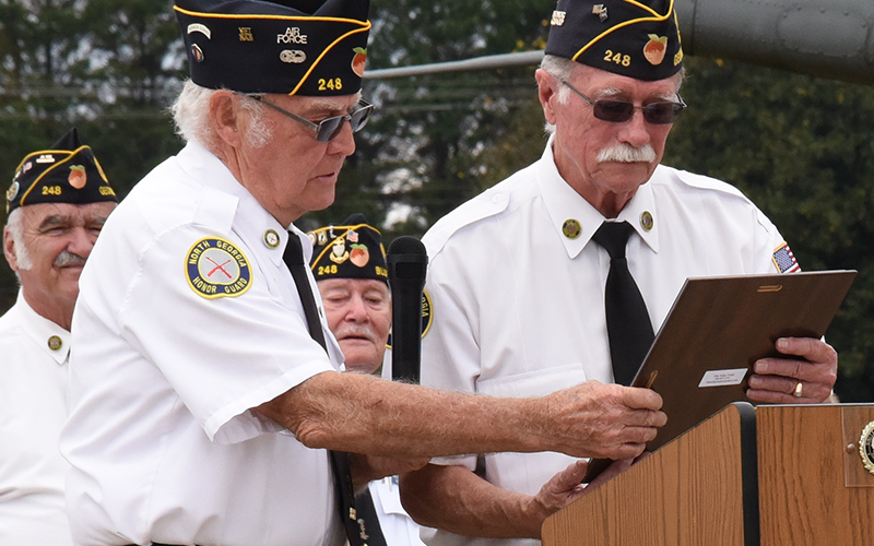 Chris McKee, left, presents North Georgia Honor Guard Commander Bill Stodghill a plaque acknowledging his dedication to the group.