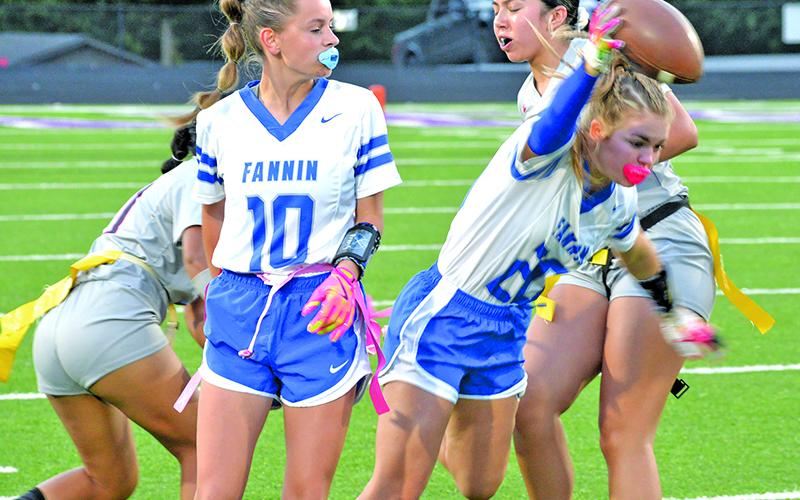 Fannin County High School flag junior Annaleigh Cheatham (#20) runs the ball while sophomore Makenzie Duvall blocks in action earlier this year.