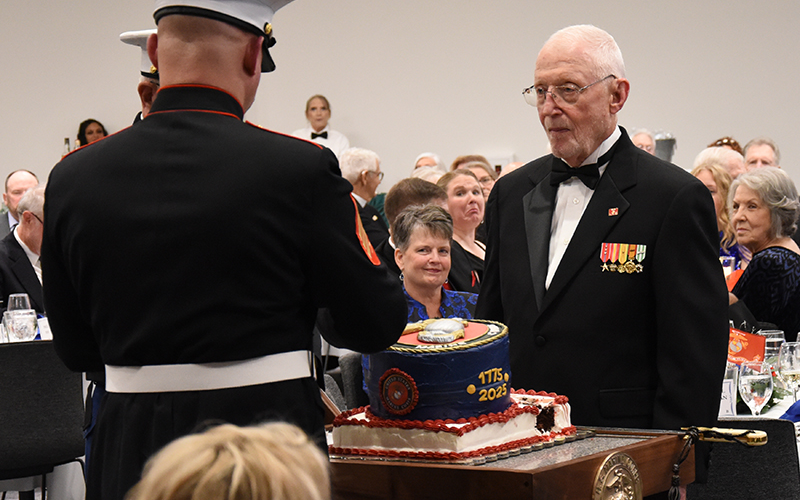 The youngest Marine present for the Marine Corps Ball, Sergeant Robert Cody (back to camera) and the oldest, Lieutenant Colonel Chris Rodatz, participate in the ceremonial cutting of the Marine Corps birthday cake.