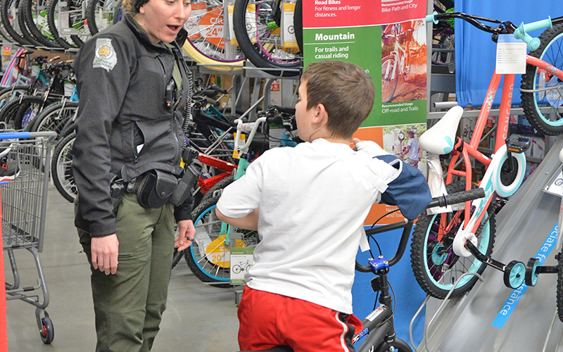 Savannah Miller, Georgia Department of Natural Resources game warden first class, helps this boy test out a new bicycle during Fannin County’s Shop With A Cop December 13.