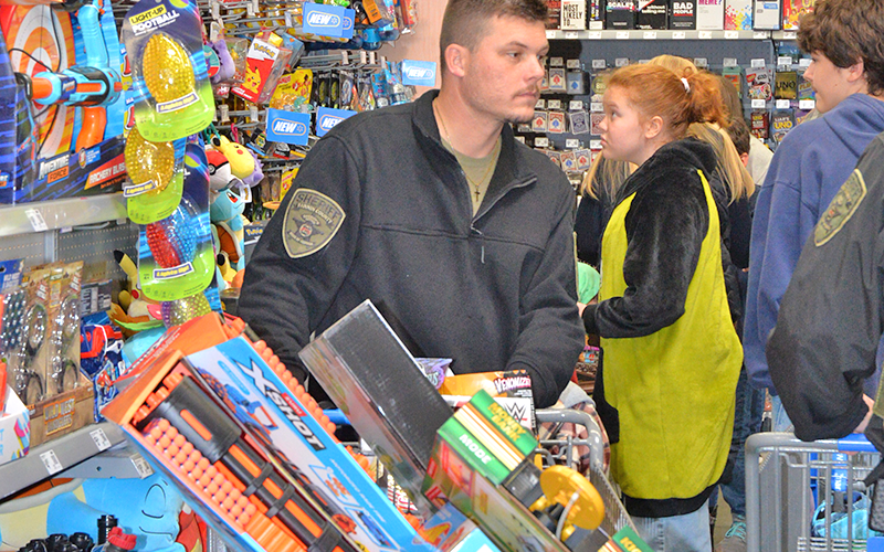 Fannin County Deputy Sheriff Corporal Matthew Peardon helps a young man during Shop With A Cop December 13.