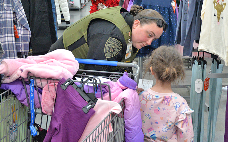 Sergeant Brittny Depuy with the Fannin County Sheriff’s Office Detention Center helps this young girl find some new clothes during Shop With A Cop.