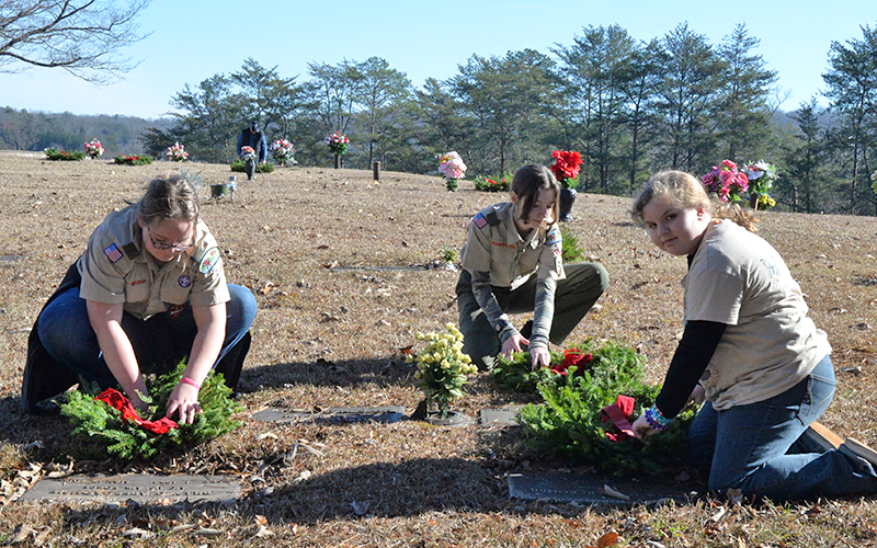 Scouts Ellee Gibbs, Raven Westphal and Lillian Powell place memorial wreaths for Wreaths Across America at JP Chastain Memorial Cemetery December 13.