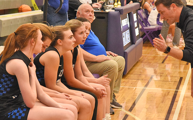 Fannin County Lady Rebel Coach Ryan Chastain, right, gives instruction to, seated, from left, Albany Cole, Reese Lewis, Maggie Ledford, Izzie Jabaley and Avi Ethington during the Piedmont Mountainside Holiday Classic tournament. - News Observer photo/Glenn Harbison