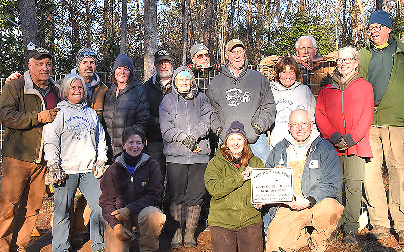 Freedom For Fido volunteers and sponsors celebrate after completing their 200th fence build for leashed dogs Sunday, January 11.