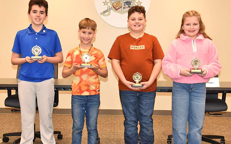 Joseph “Joey” Vogel, Abishai Rittweger, Lincoln Harriman and Hayslee Lunsford, from left, received their trophies for winning the spelling bees at their individual schools before the start of the county wide event.